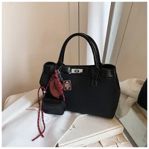 Stylish black handbag for women, casual crossbody bag with cute charms, minimalist autumn style.