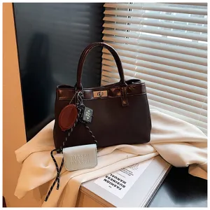 Brown minimalist top-handle bag with turn-lock closure and cute charms for daily wear.
