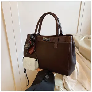 Detail view of the brown autumn handbag with mini pouch charm, casual and elegant style.