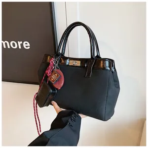 Black fashion women handbag casual tote shoulder bag with chic charms and turn-lock closure.