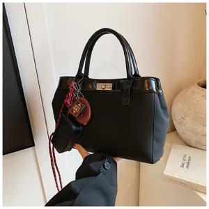 Minimalist black handbag for women, chic top-handle tote bag with stylish accessories.