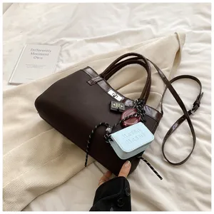 Stylish dark brown top handle crossbody bag for women, chic casual handbag with charms.