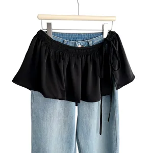 Black ruffled waist skirt layered with light blue denim jeans, trendy fashion piece.