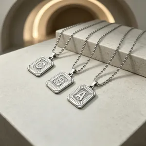 Stainless steel initial letter pendant necklace, detailed view of charms and rope chain.