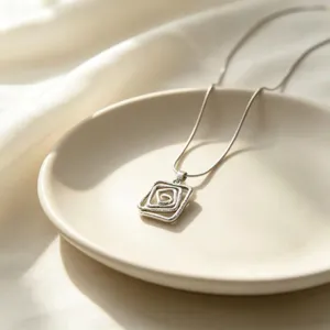 Gros plan détaillé d'un collier pendentif en spirale géométrique élégant et moderne.