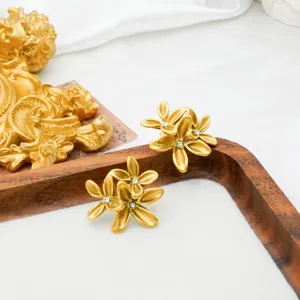 Detailaufnahme von goldenen Vintage-Blumen-Ohrringen mit funkelnden Zirkoniasteinen.