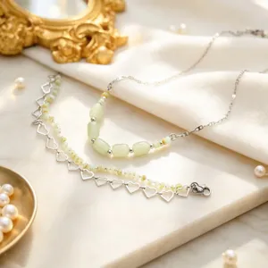 Detail shot of light green beaded necklace and heart hollow bracelet set, chic niche fashion.