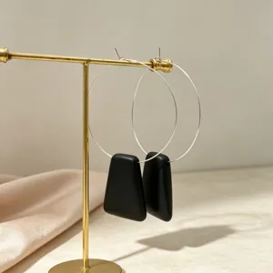 Minimalist gold hoop earrings with black geometric pendant, elegant detail shot for chic daily wear.