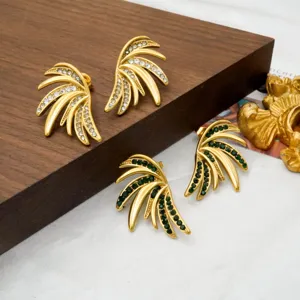 Gold-plated rhinestone wing earrings detailed view featuring clear and green crystals.