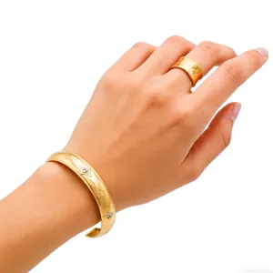 Gold stainless steel open cuff bracelet and wide ring set with diamond floral motifs for women.
