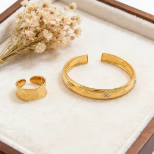 Gold stainless steel diamond open cuff bracelet and ring set, elegant jewelry detail.