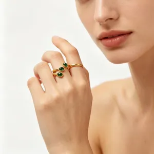 Close-up detail of luxury green oval gemstone gold stainless steel spiral ring set.