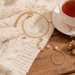 Elegant gold-tone hand chain bracelet with delicate pearl accents for chic daily style.