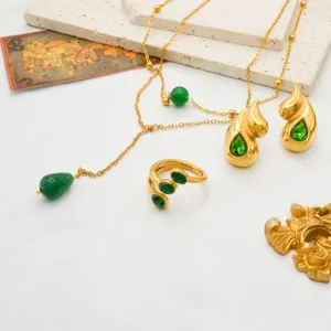 Detailed shot of retro gold-tone stainless steel green rhinestone jewelry set necklace earrings.