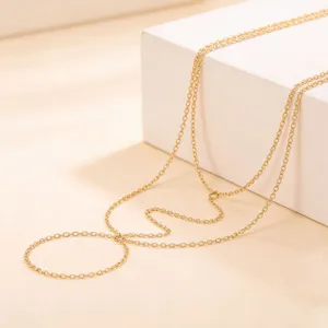 Delicate multi-layer gold tone hand chain bracelet, minimalist chic jewelry detail view.