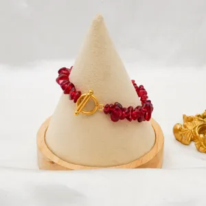 Detail view of irregular red crushed stone bracelet with gold-plated OT toggle clasp.