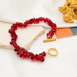 Close-up detail of irregular red chip stone bracelet featuring a shiny gold OT clasp design.