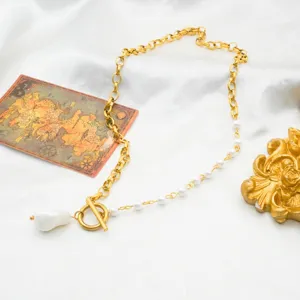 Close-up of asymmetric OT clasp necklace, 18k gold plated stainless steel with baroque pearl.