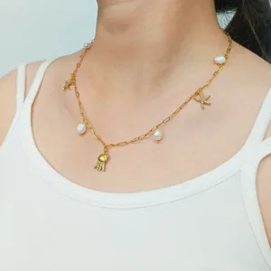 Gold-plated stainless steel necklace with pearls, starfish, and jellyfish pendants for beach vacations.