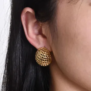 Close-up detail of textured woven gold dome earrings worn on ear, elegant chic design.
