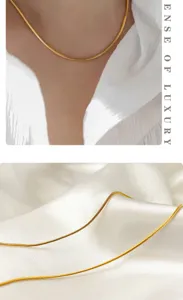 Gold snake chain necklace detail showing delicate double-layer design and smooth texture.