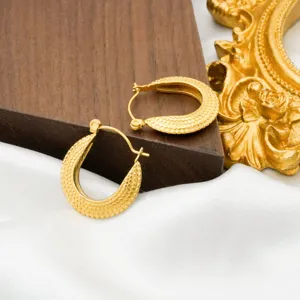 Close-up of 18k gold plated U-shaped textured stainless steel hoop earrings with luxury design.