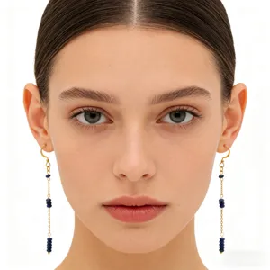 Detailed close-up of long lapis lazuli tassel earrings worn by a model, showing gold hooks.