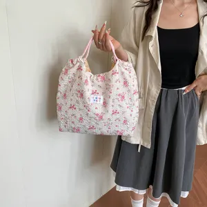 Detailed view of the cute floral canvas tote bag, showing pink straps and small brand label.