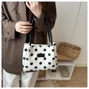 Vista dettagliata della borsa tote a pois casual con manici intrecciati e capienza utile.