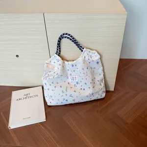 Detailed shot of a floral shirred tote bag with rope handles placed near a wooden cabinet.