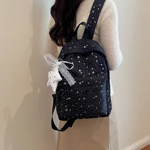 Vue de détail du sac à dos élégant imprimé d'étoiles avec un pendentif en dentelle.