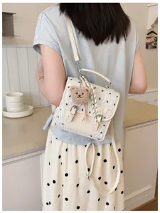 College style bow print mini backpack detailed view showing cute bear pendant and straps.