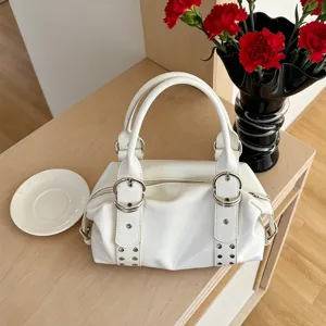 Retro white PU leather Boston handbag detail featuring stylish metal rings and rivet decorations.