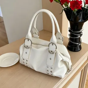 White PU leather Boston handbag detail featuring metallic double buckles and studs.