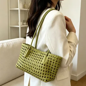 Detailed shot of a green woven shoulder bag with hollow-out design for summer beach and vacation.