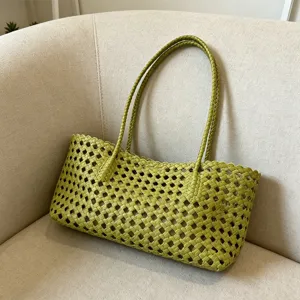 Detail shot of green hollow woven beach bag, summer vacation basket tote for women.