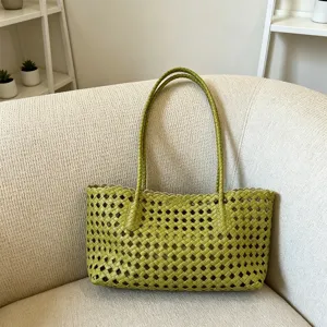 Detailed close up view of the green woven leather handbag texture and scalloped edge design.