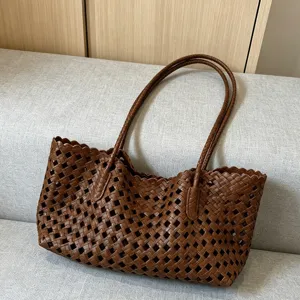 Brown woven leather tote bag detail, featuring an intricate openwork pattern and scalloped rim.