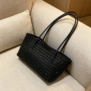 Black woven tote bag detail showing hollow texture and delicate strap design for summer.
