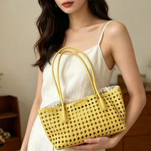Close-up detail of yellow woven hollow beach tote bag with lace trim in lifestyle scene.