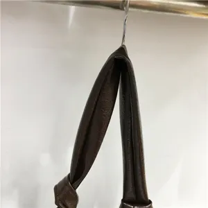 Close-up detail of brown soft leather slouchy shoulder crossbody dumpling bag strap.