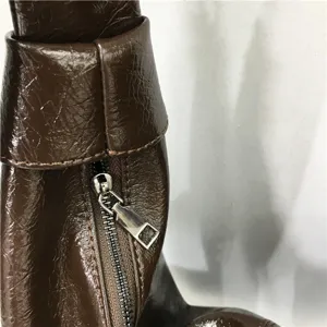 Brown glossy crinkled leather shoulder bag zipper detail closeup, casual daily accessory.