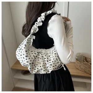 Vista dettagliata della borsa a spalla floreale con un elegante manico con volants.