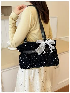 Dettaglio della borsa a spalla nera a pois, con fiocco di perle e design coreano chic e alla moda.