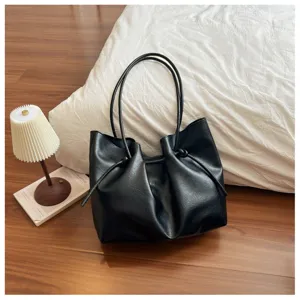 Detailed view of the black faux leather tote bag with stylish gathered design and shoulder strap.