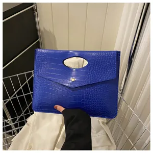 Borsa a pochette in ecopelle coccodrillo blu con manico intagliato e bottone a pressione.