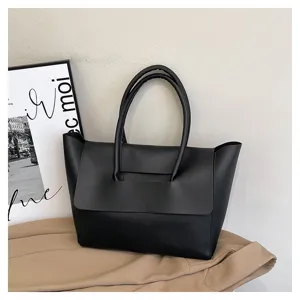 Vista de detalle del bolso tote negro minimalista, gran capacidad y elegante diseño.