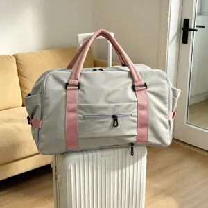 Dettaglio borsa da viaggio in nylon grigio e rosa, tasca per manico valigia, separazione.