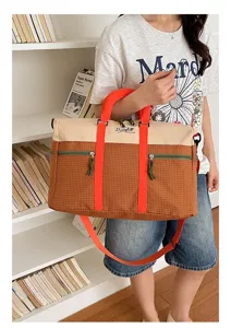 Color-block travel duffel bag detail, large capacity canvas sport gym bag with top handles.
