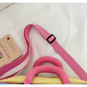 Nahaufnahme des bunten, farblich abgesetzten Reisetaschen-Schulterriemens und Griffs.